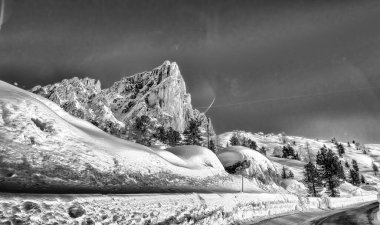 Road through a beautiful snowy valley, dolomite mountains in winter season.