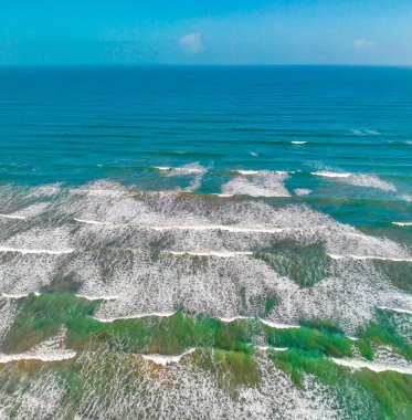Beautiful waves along the shoreline, overhead aerial view from drone.