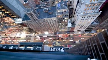 Downward aerial view of city traffic in Midtown Manhattan at night. New York buildings and cars from a high vantage point.