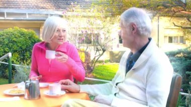 Active seniors outdoor. An elderly couple making breakfast in the garden.