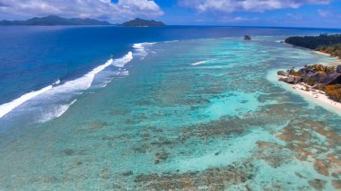 Drone 'dan Mercan Kayalıkları' na. Güneşli bir günde Seyşeller plajı ve kayalar.