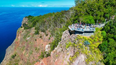 Tourists enjoy the viewpoint at Cabo Girao, along the Madeira coastline, Portugal. Aerial view from drone.