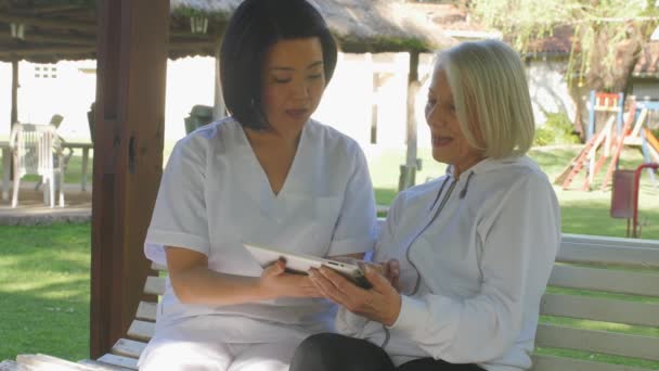 Slow Motion Asian Female Doctor Helping Elderly Woman Using Tablet — Vídeos de Stock