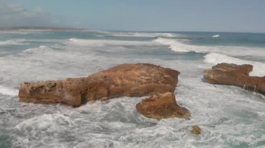 Süper ağır çekim deniz dalgalarının yüzey kaya, havadan görünümü kırma.