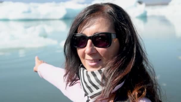 Uśmiechnięta Kobieta Wskazująca Góry Lodowe Laguny Jokulsarlon Islandia — Wideo stockowe