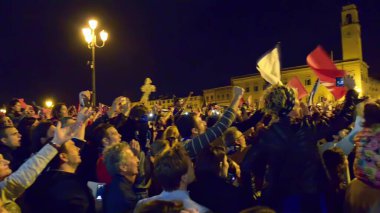 PISA, ITALY - JUNE 15TH, 2016: Local fans celebrate the soccer team's promotion. Celebrations in the night with smoke bombs and an open bus.