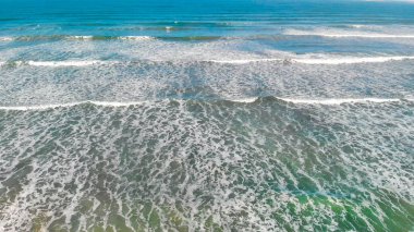 Aerial view of gentle waves along the beautiful shoreline.