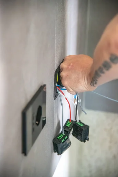 电工将电源插座安装到墙上 将电缆连接起来 — 图库照片