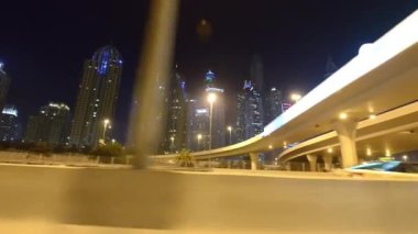 Dubai Şehir Merkezi gökdelenleri gece hareket halindeki bir arabadan.