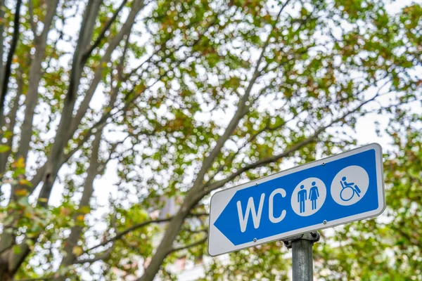 城市里有一个Wc标志 背景里有树木 — 图库照片