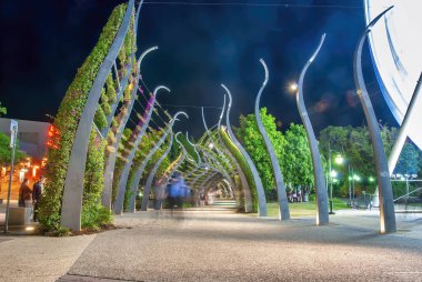 Brisbane, Australia - August 14, 2009: Tourists along the South Bank Grand Arbour at night. It is a 1km long arbour, curled spires draped in ever blooming bougainvillea.