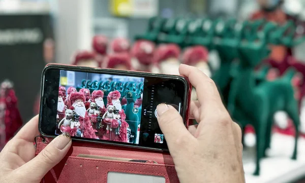 Женщина Фотографирует Красивые Рождественские Украшения Своим Смартфоном — стоковое фото