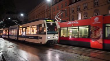 Viyana, Avusturya - Ağustos 2022: Yağmurlu bir gecede şehir merkezinde iki tramvay.