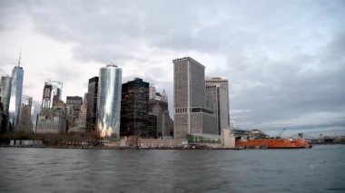 NEW YORK CITY - 2018 ARALIK: Hareket halindeki bir tekneden günbatımında Aşağı Manhattan 'ın modern ufuk çizgisi.
