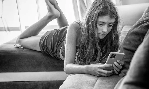Jovem Feliz Relaxando Sofá Brincando Com Smartphone — Fotografia de Stock