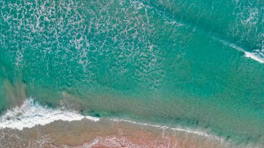 Above the ocean, aerial view at the waves and surface near shoreline - Drone viewpoint.
