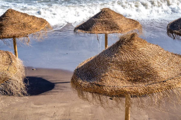 Szalma Strand Esernyők Mentén Egy Gyönyörű Partvonal Alkonyatkor — Stock Fotó