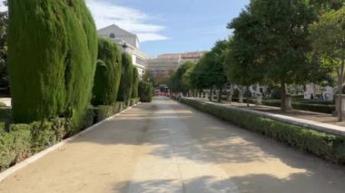 Madrid, Spain - October 29, 2022: Tourists walk along Plaza de Oriente gardens in front of Royal Palace.