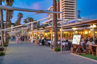 Malaga, İspanya - 14 Nisan 2023: Turistler liman yakınlarında gün batımının keyfini çıkarıyorlar.