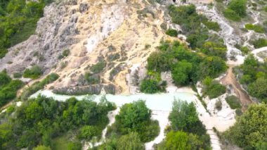 Bagno Vignoni doğal havuzları Tuscany 'deki şehir tepesi boyunca, bahar mevsiminde insansız hava aracı manzarası.