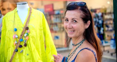 Mutlu kadın sarı bir elbise seçiyor..