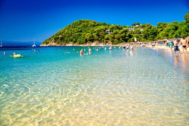 Skiathos, Yunanistan - 6 Temmuz 2023: Turistlerle Koukounaries Plajı.
