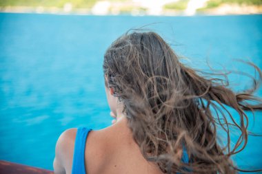 Yaz mevsiminde kıyı şeridine bakan güzel bir kızın arka manzarası..