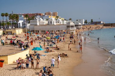 Cadiz, İspanya - 8 Nisan 2023: Şehir plajı boyunca turistler.