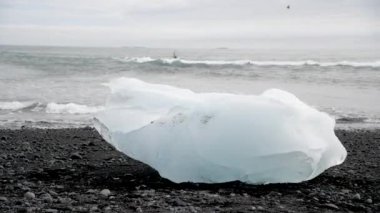 Jokulsarlon gölü, İzlanda. Bir yaz sabahı, siyah sahilde buzdağı..