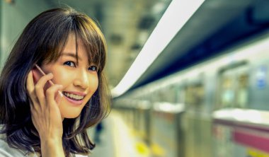 Akıllı telefon kullanan Asyalı bir kız. İş ve eğlence kavramı.