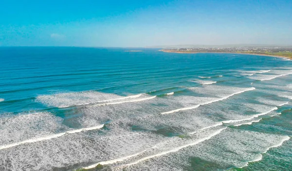 Aerial view of gentle waves along the beautiful shoreline.