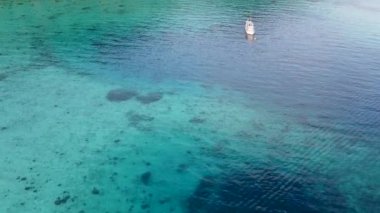 Güzel mercan resifinin üzerinde renkli bir tekne, yukarıdaki hava manzarası..
