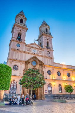 Cadiz, İspanya - 8 Nisan 2023: Günbatımında Iglesia de San Antonio boyunca turistler.