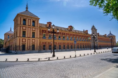 Sevilla, İspanya - Nisan 2023: Güneşli bir günde Sevilla Katedrali boyunca turistler.