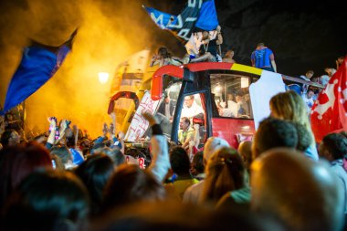 PISA, ITALY - JUNE 15TH, 2016: Local fans celebrate the soccer team's promotion. Celebrations in the night with smoke bombs and an open bus.