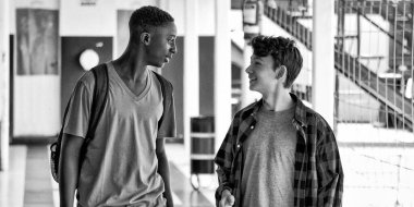 Kafkasyalı ve Afrikalı gençler okul koridorunda konuşuyorlar..