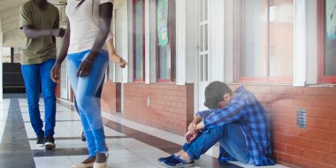 Genç beyaz, okulda üzgün bir şekilde tek başına oturuyor. Depresyondaki çocuk bir koridorda terk edildi ve tuğla duvara yaslandı. Zorbalık, ayrımcılık ve ırkçılık kavramı.