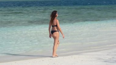 Güzel bir kadın sahilde yürüyüş yaparken dinleniyor..