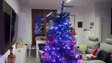 Modern bir evde renkli ışıklarla Noel Ağacı süslemek.