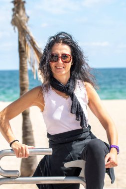 Mutlu güzel bir kadın plajda oyun parkında dinleniyor..