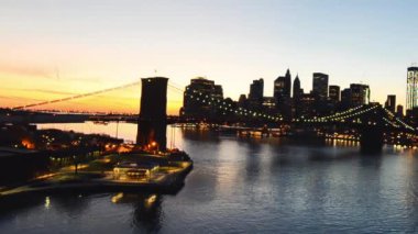 Gün batımında New York 'ta. Brooklyn Köprüsü ve Manhattan ufuk çizgisi.
