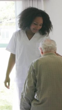 Afroamerikan doktor hastanede yaşlılara yardım ediyor. Dikey Video.