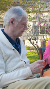 Masada dışarıda vakit geçirmeyi seven bir çift yaşlı insan. Dikey Video.