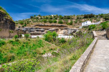 Setenil de las Bodegas. Tipik Endülüs köyü. Beyaz evleri ve Rio Trejo 'nun tepesinde kayalara inşa edilmiş evleri var..