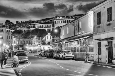 Sanremo, İtalya - 2 Ocak 2024: Geceleri liman boyunca şehir sokakları.