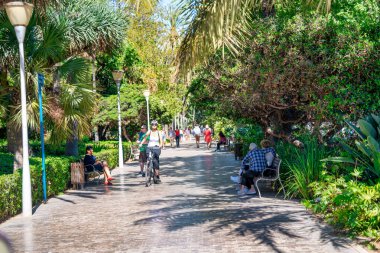 Malaga, İspanya - 14 Nisan 2023: Turistler okyanus kıyısındaki gezintinin tadını çıkarıyor.