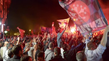 PISA, ITALY - JUNE 15TH, 2016: Local fans celebrate the soccer team's promotion. Celebrations in the night with smoke bombs and an open bus.