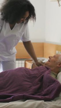 Kadın doktor hastanedeki hastalara yardım ediyor. Dikey Video.