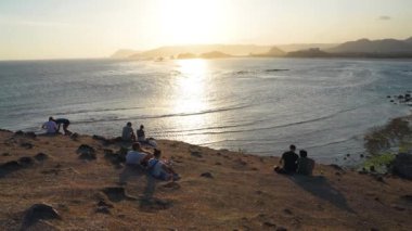 Yerel halk ve turistler Bali, Endonezya 'da günbatımının keyfini çıkarıyorlar.