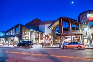 Jackson Hole, WY - 11 Temmuz 2019: Şehir sokakları ve arabaları gün batımında.